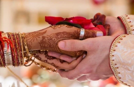 a couple holding hands with henna designs