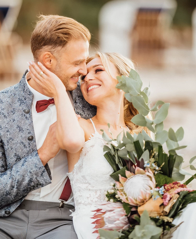 a man and woman smiling and holding flowers
