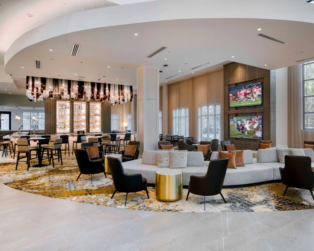 a large room with a large round couch and a bar