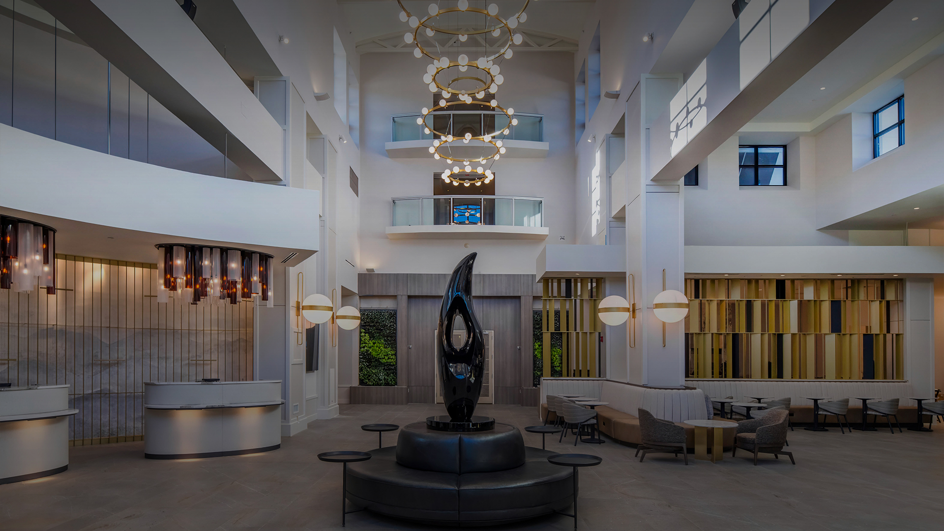 a large lobby with black sculpture in a room with a chandelier