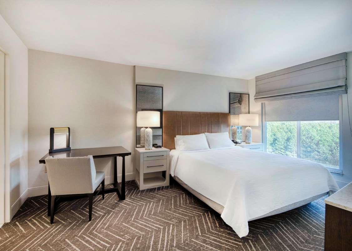 a hotel room with a bed and a desk