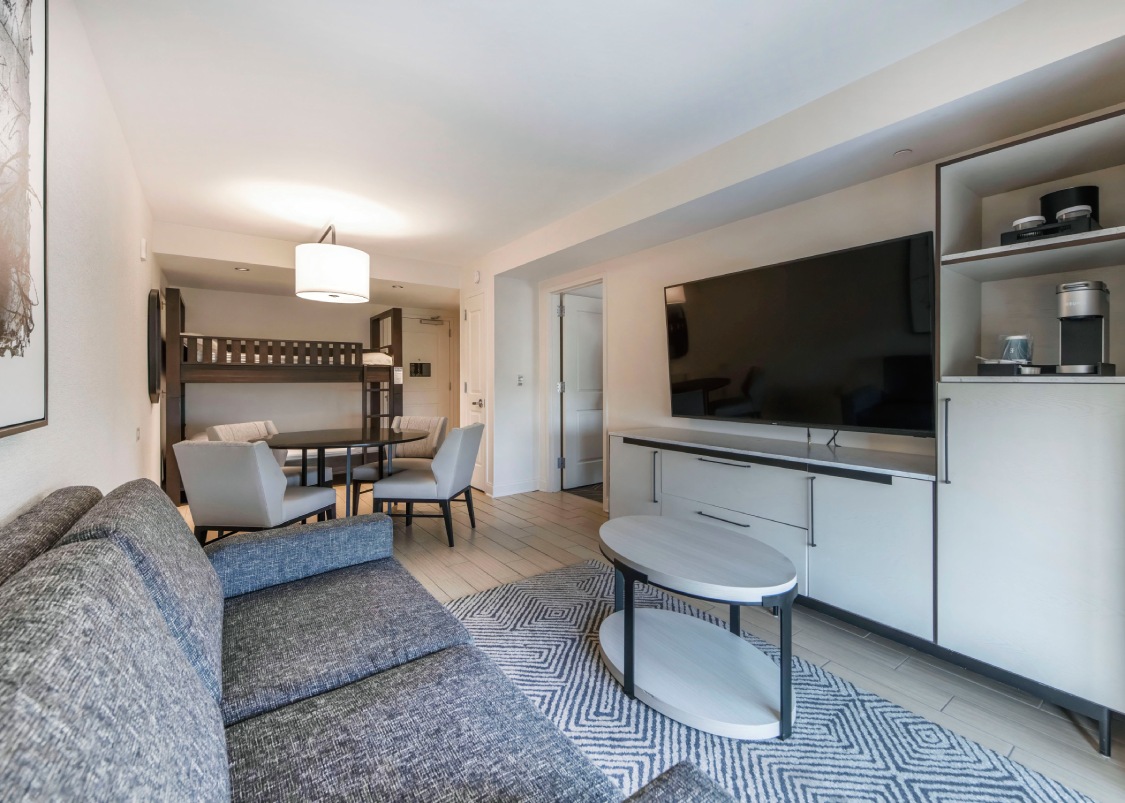 a hotel living room with a couch and a tv