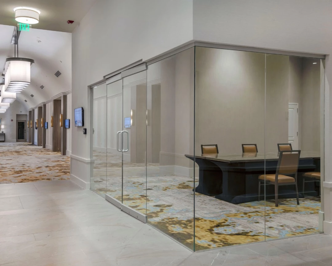 a hotel meeting room with glass windows 