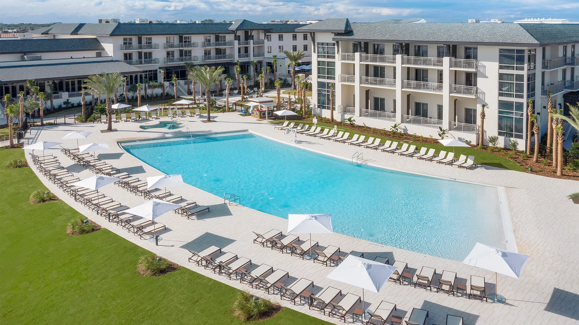 a swimming pool with lounge chairs and umbrellas