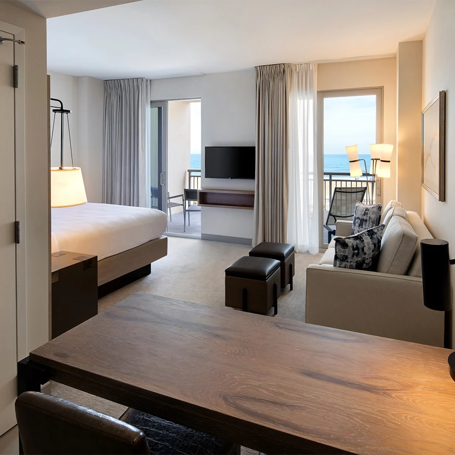 a room with a bed and a table and a television