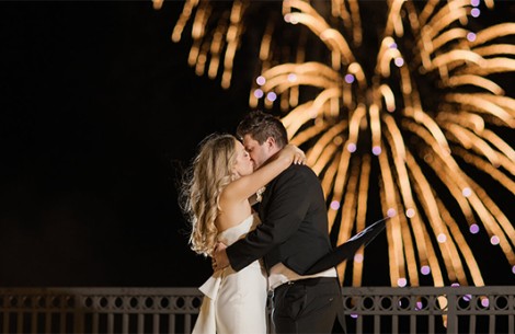 a man and woman kissing in front of fireworks