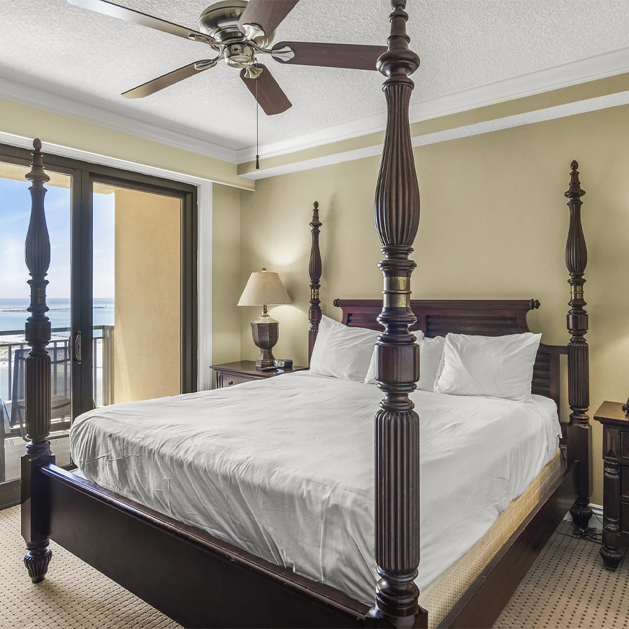 a bedroom with a four poster bed and a ceiling fan