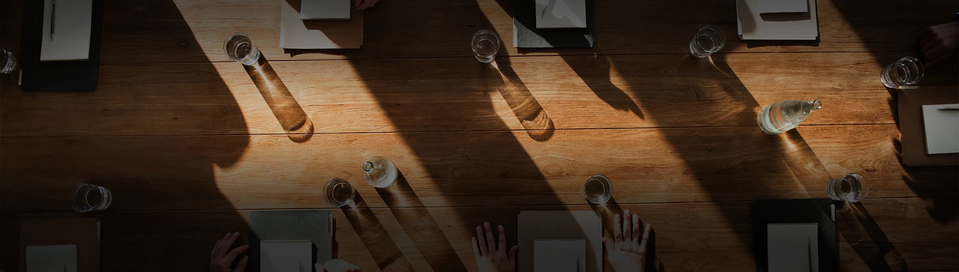 a table with a few glasses of water and a hand on it