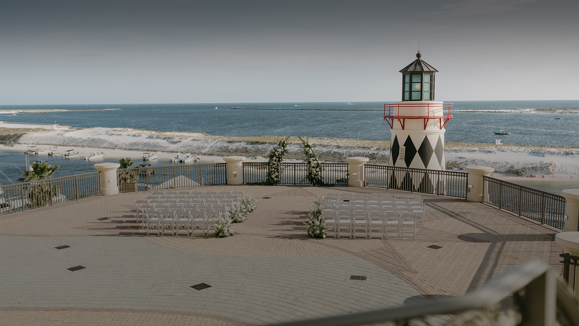 a lighthouse with chairs and a beach in the background