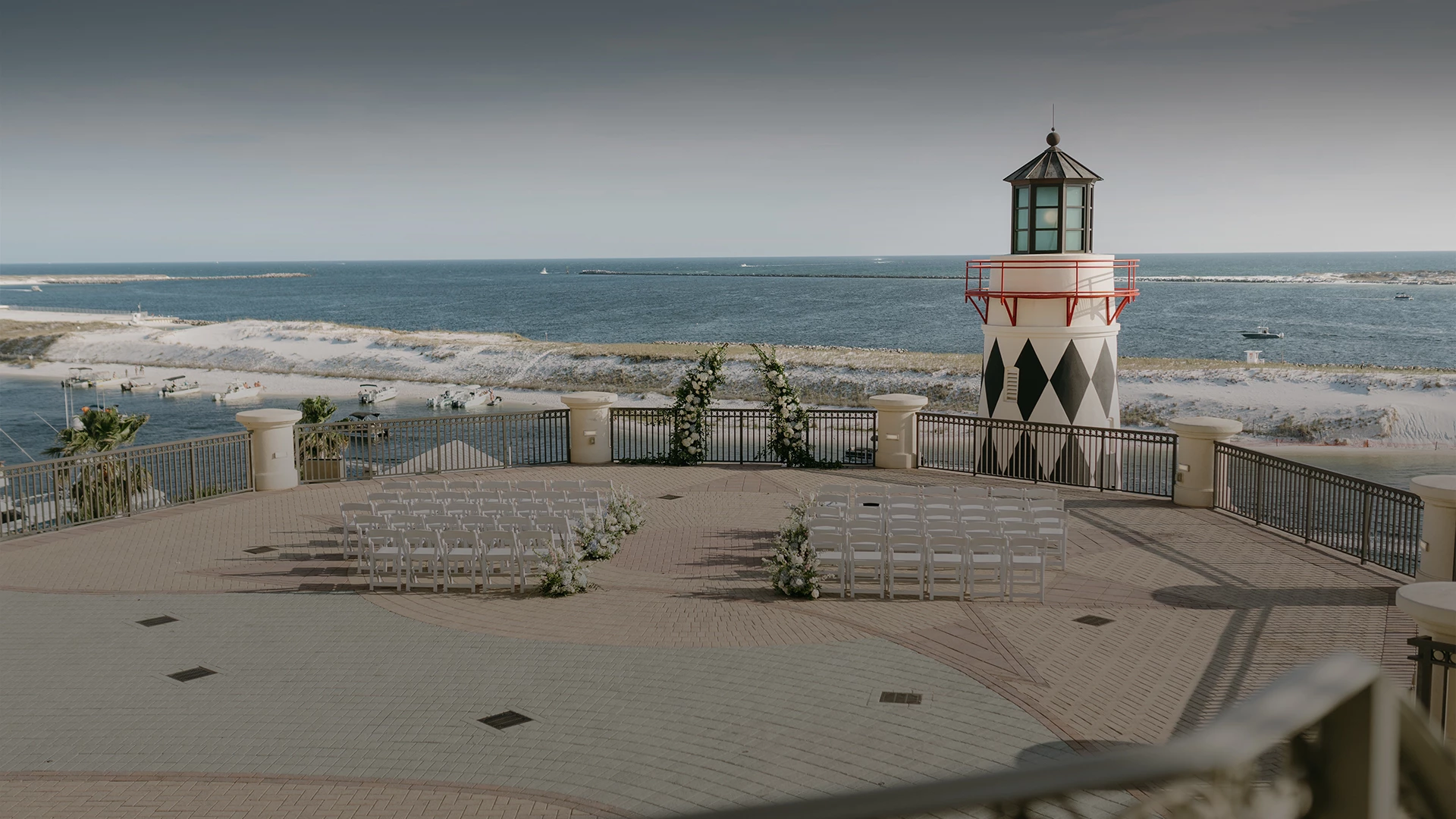 a lighthouse with chairs and a beach in the background