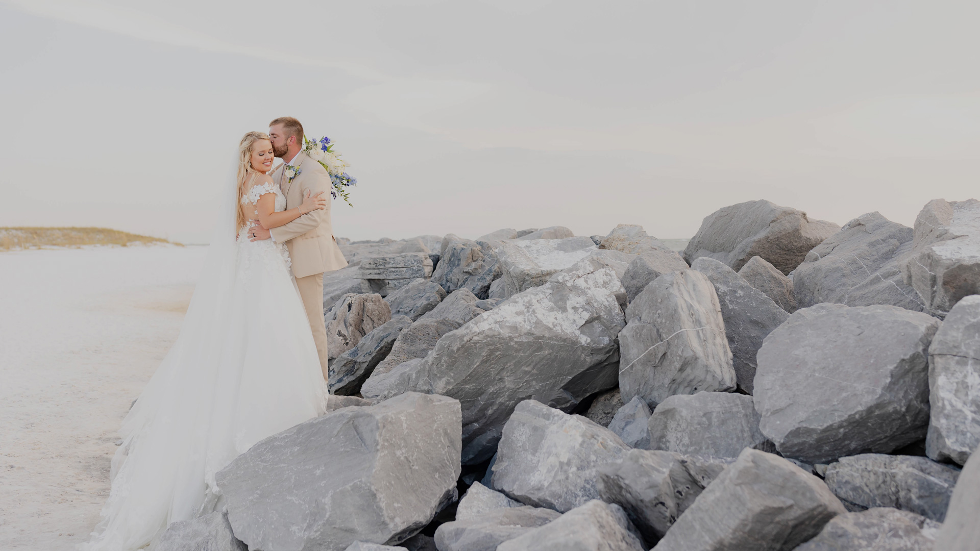 a man and woman in wedding dress standing on rocks