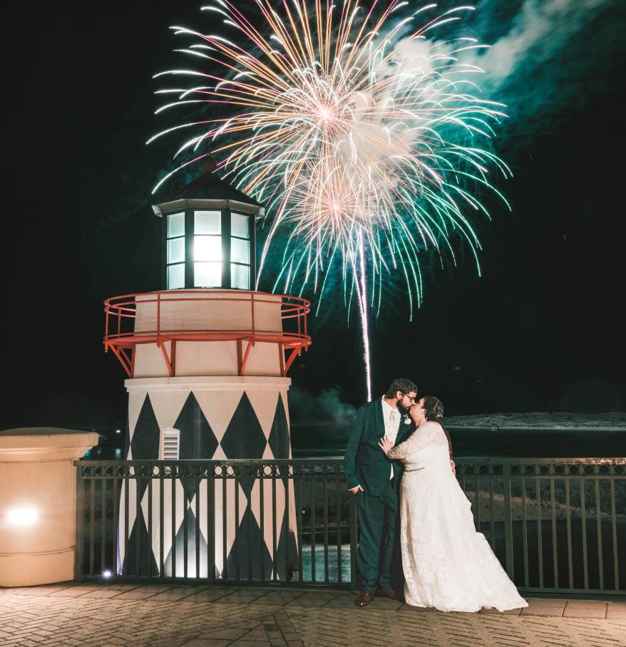 a couple kissing in front of fireworks
