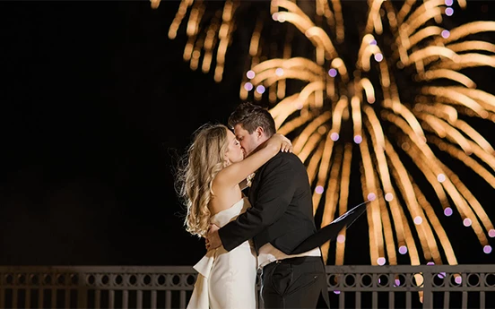 a man and woman kissing in front of fireworks