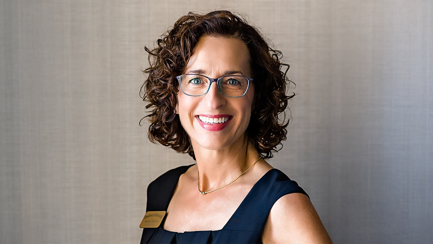 a woman wearing glasses and smiling