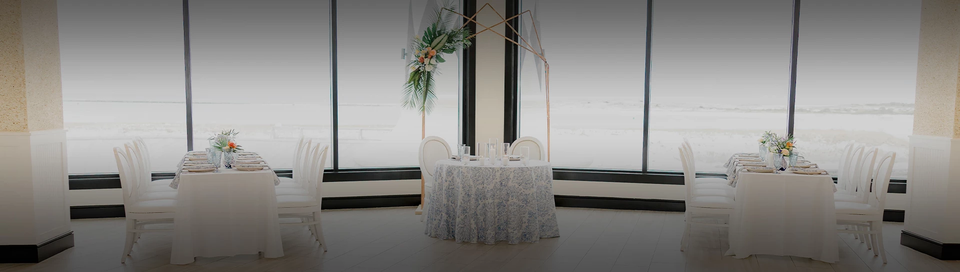 a table with a floral tablecloth and a tall plant