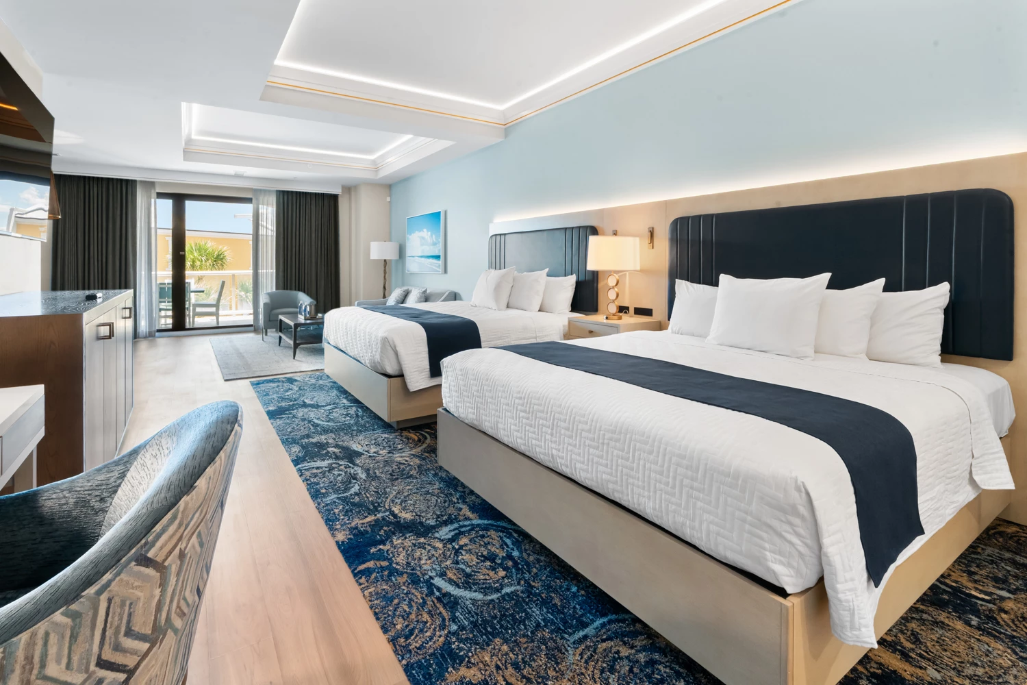 a room with two beds and a blue rug