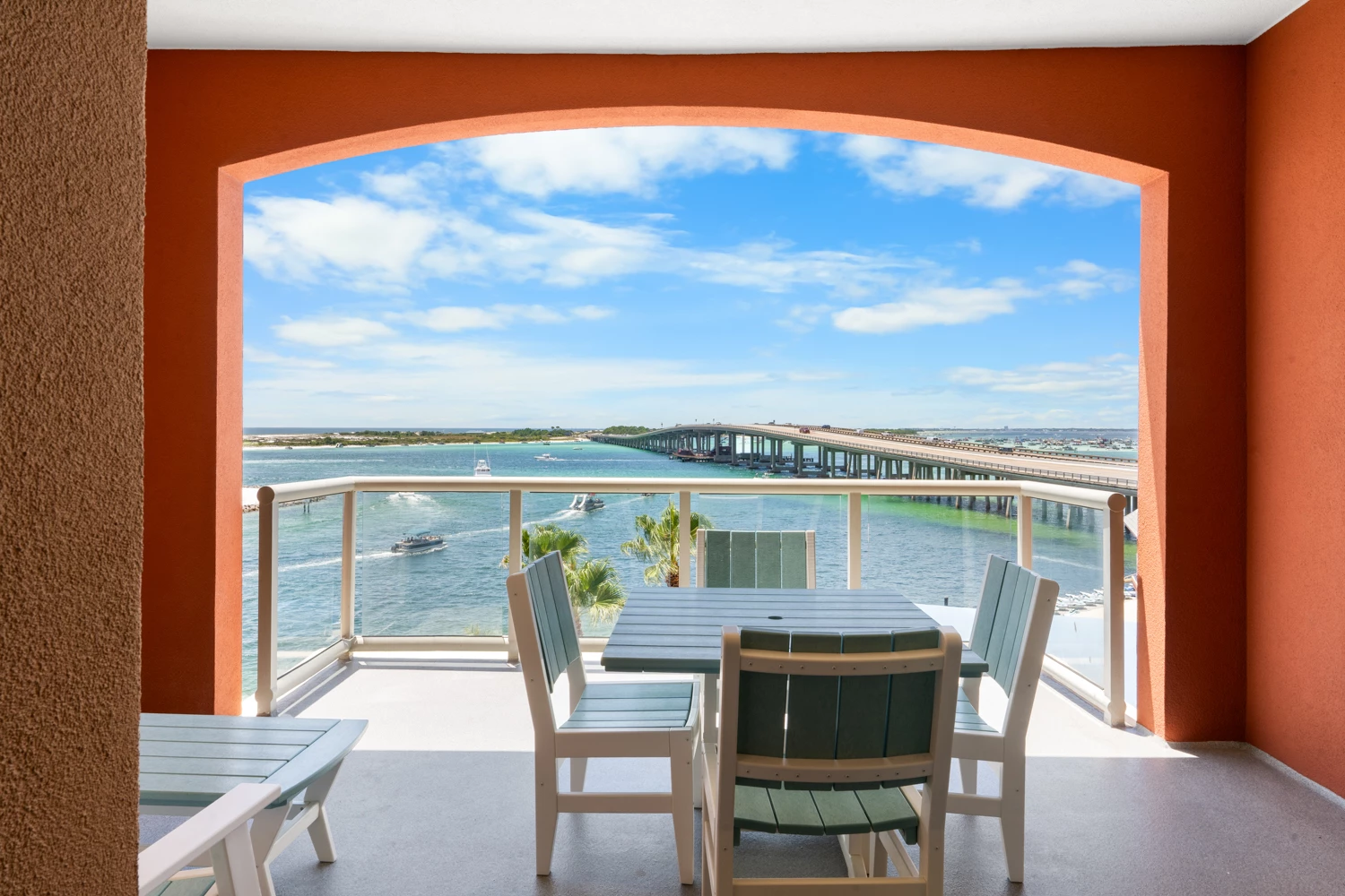 a table and chairs on a balcony overlooking a body of water