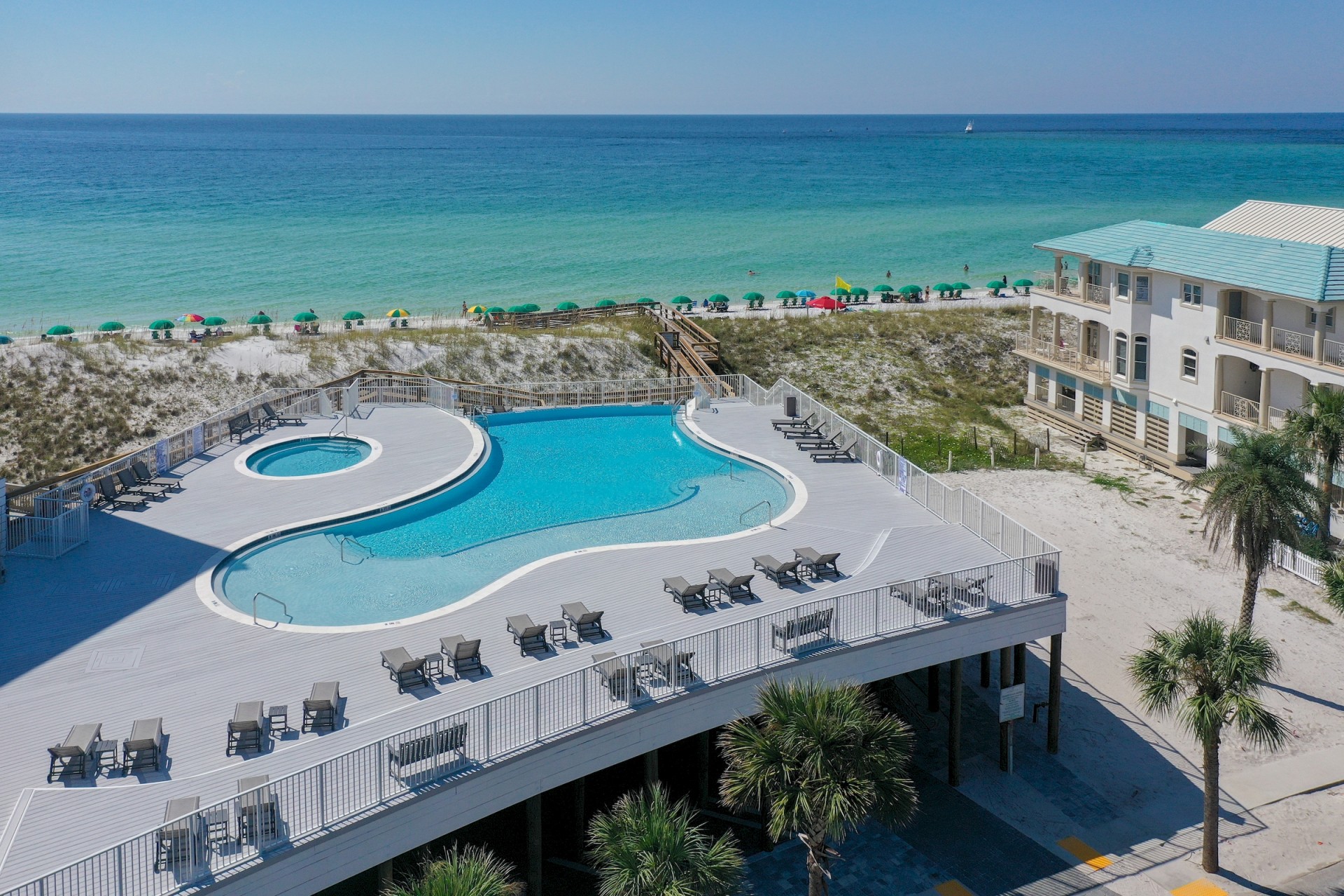 a swimming pool and a building with a beach and blue water