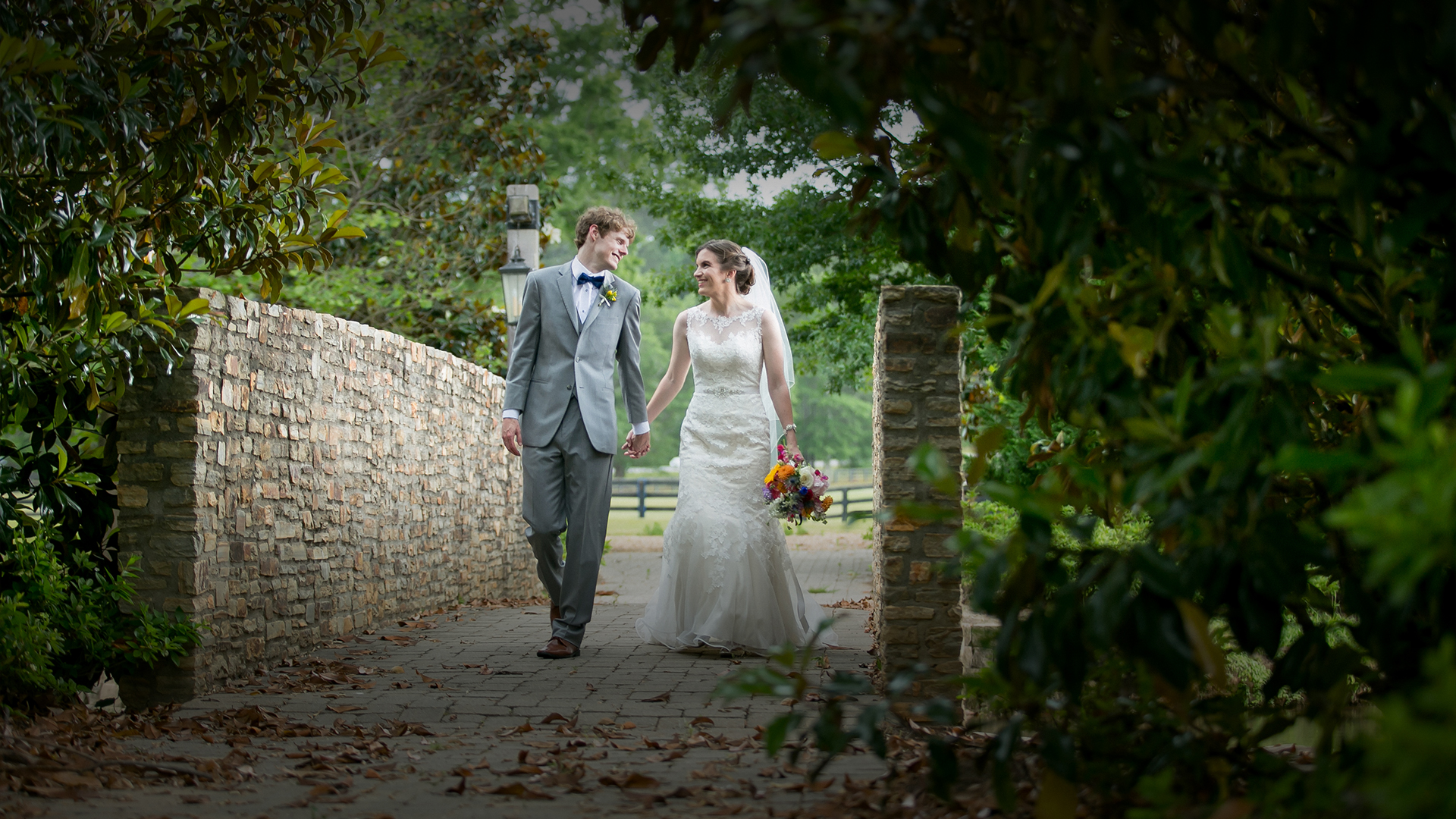 a man and woman in wedding attire walking down a path