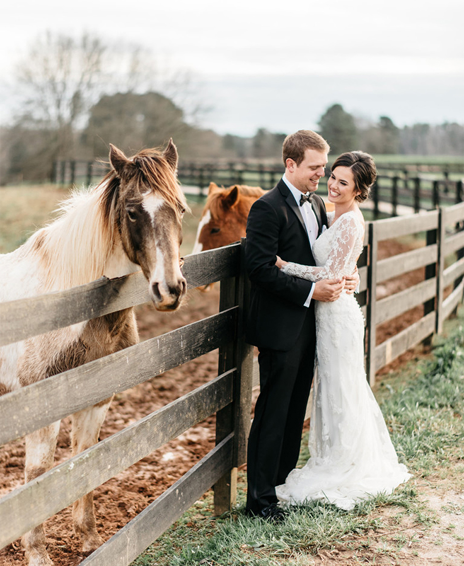 a man and woman standing next to a horse