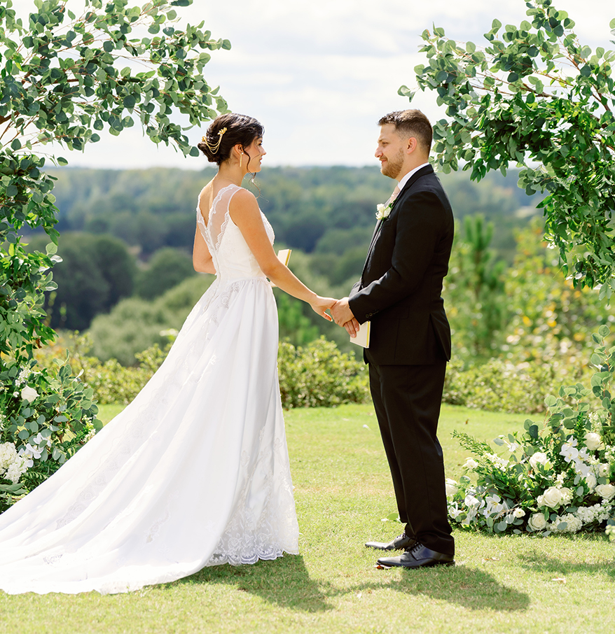 a bride and groom holding hands in a garden