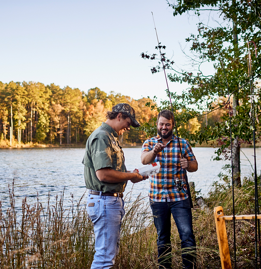 a man holding a fishing pole next to another man