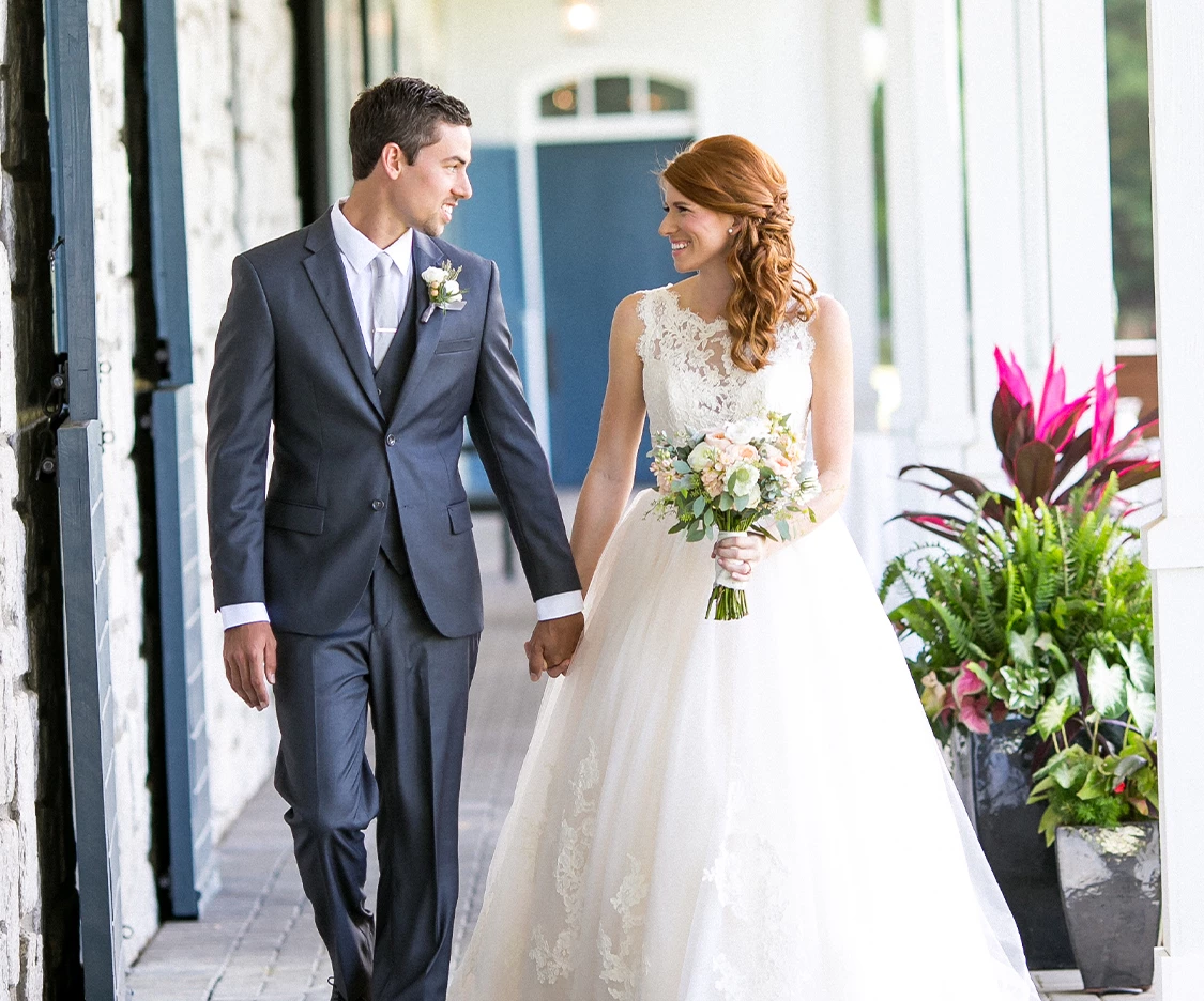 a man and woman holding hands and walking