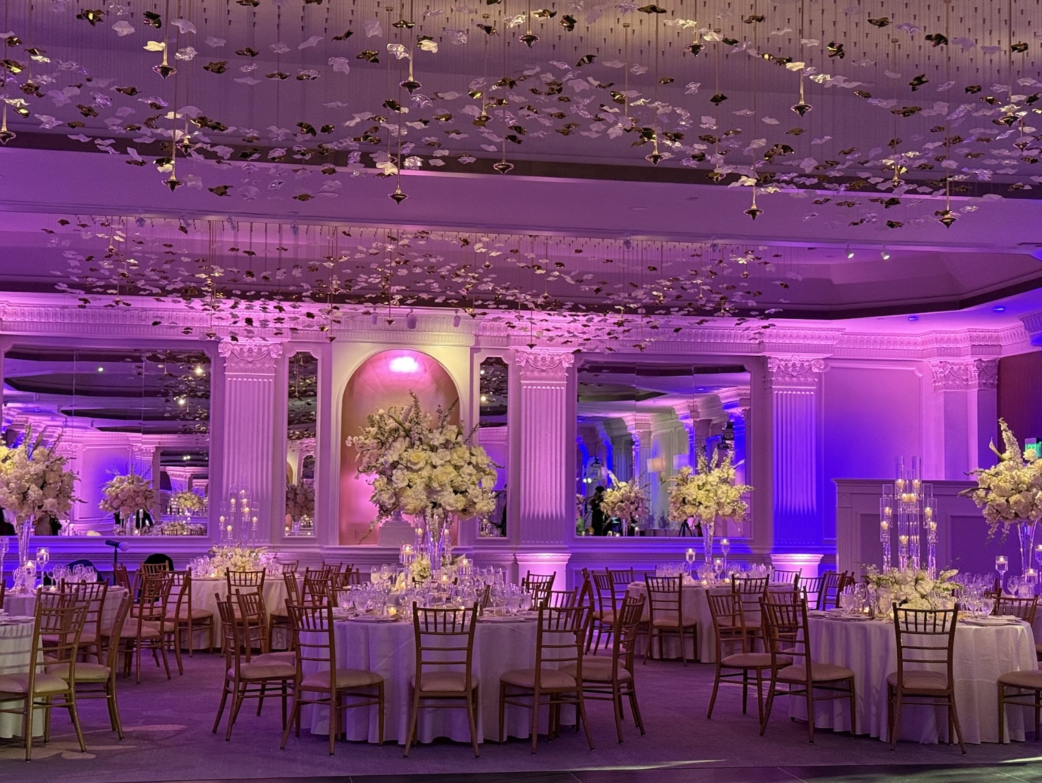 a room with tables and chairs and flowers