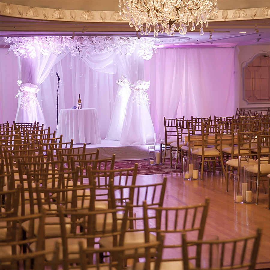 a room with chairs and a table with a chandelier
