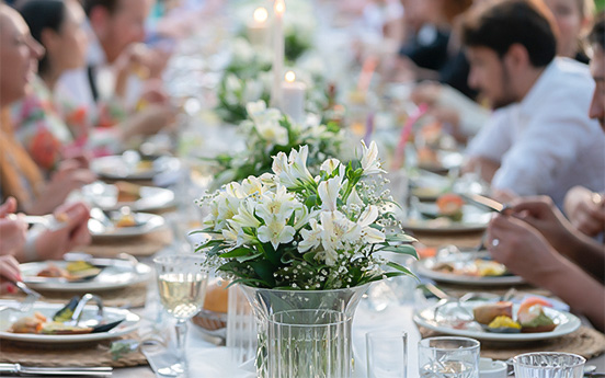 a group of people sitting at a table with flowers