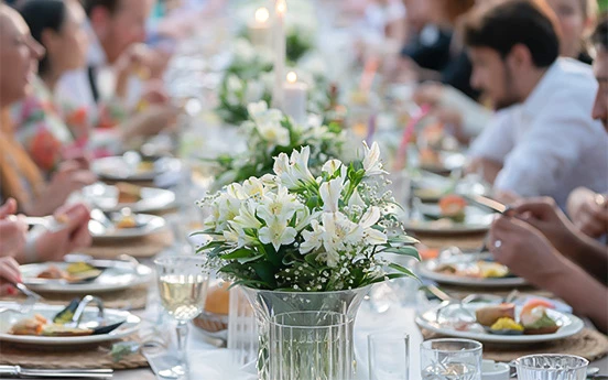 a group of people sitting at a table with flowers