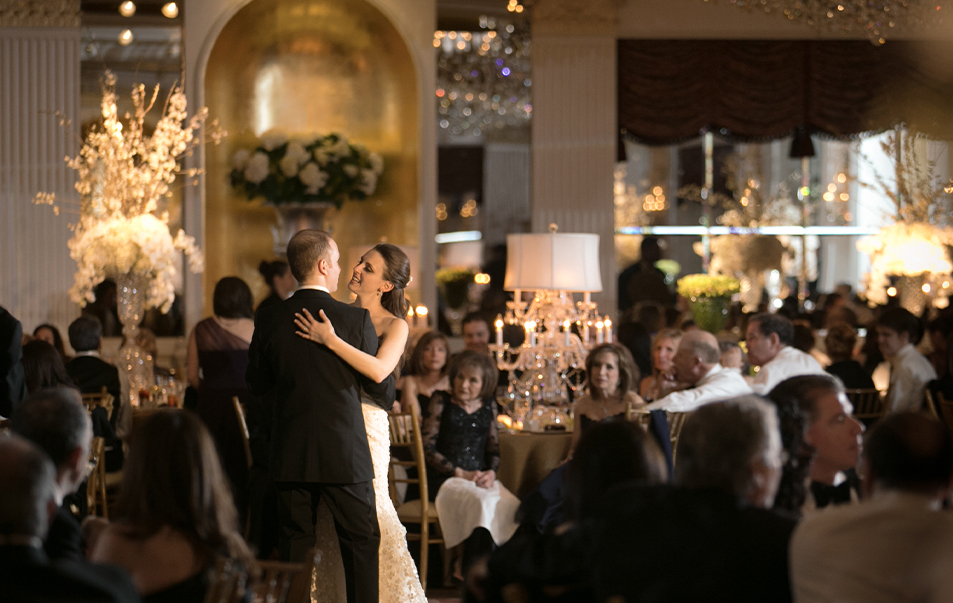 a man and woman dancing in a room with people in the background