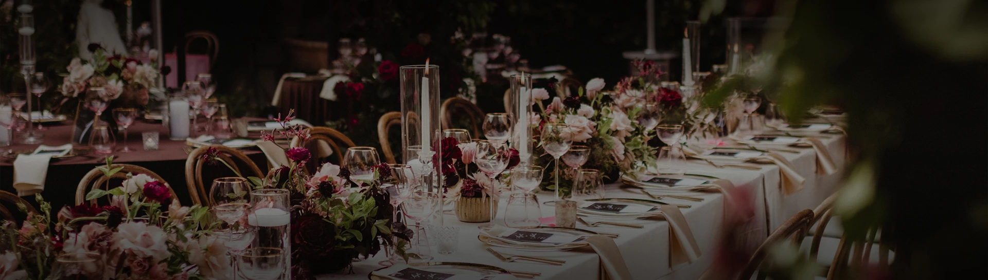 a table set with wine glasses and flowers