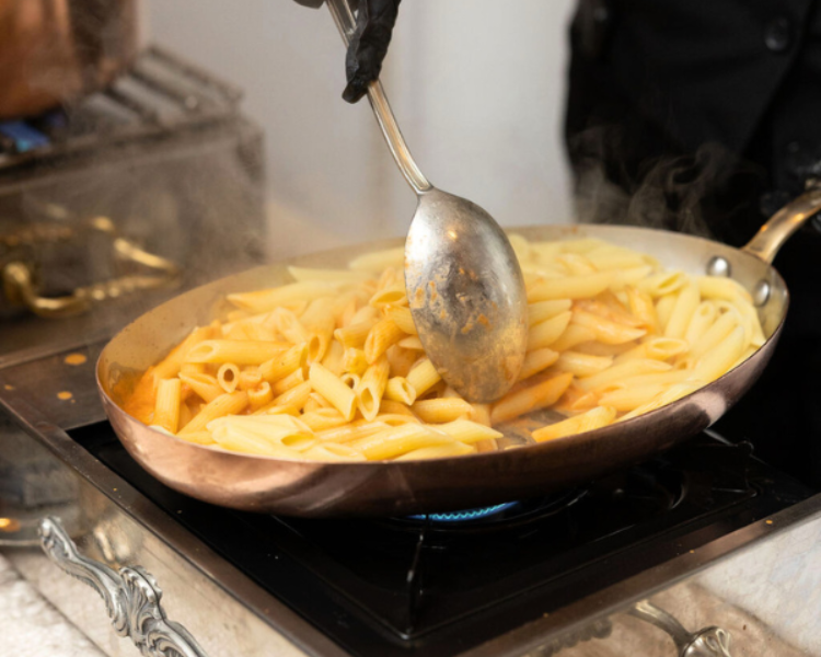 a person cooking pasta in a pan