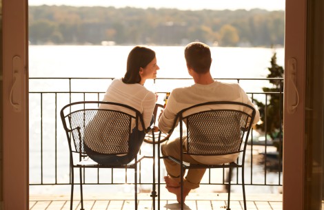 a man and woman sitting on chairs by a lake