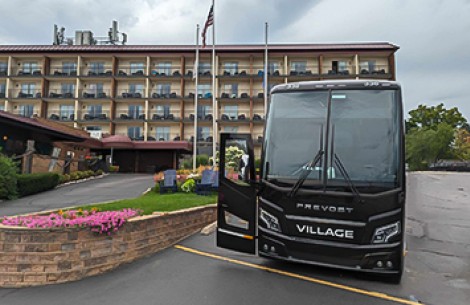 a black bus parked in front of a building