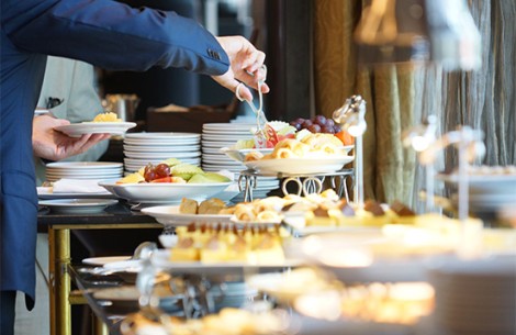a person serving food at a buffet