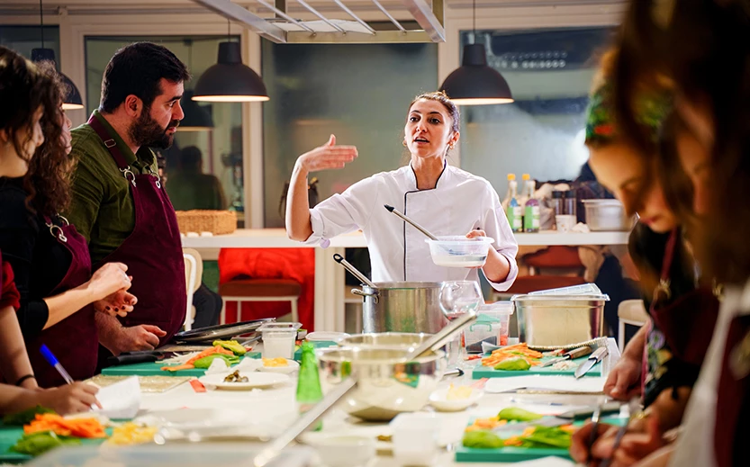 a woman in a chef's uniform standing in a kitchen