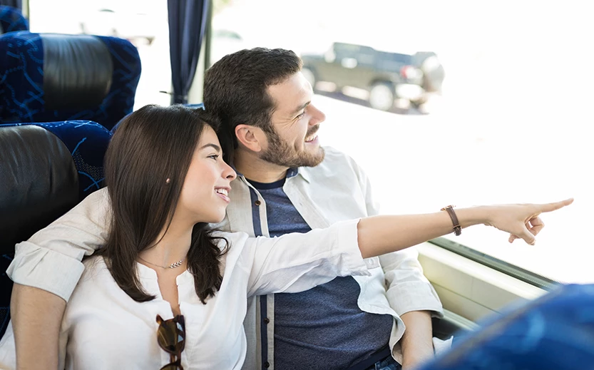 a man and woman sitting on a bus looking at something