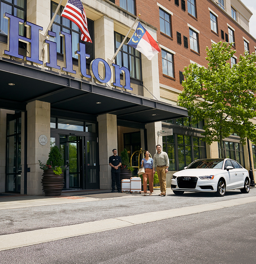 a group of people standing in front of a hotel