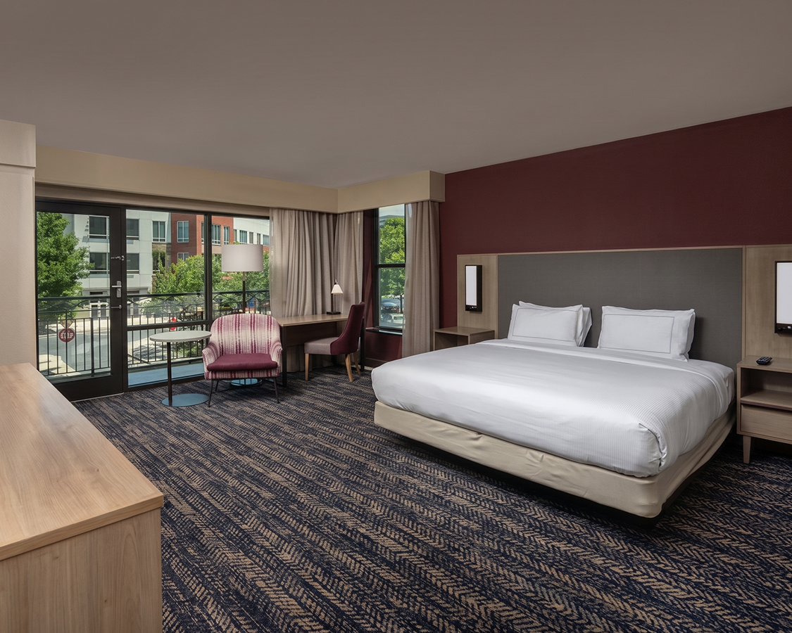a hotel room with a bed and chairs