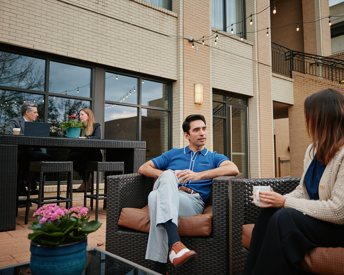 a group of people sitting outside on a patio