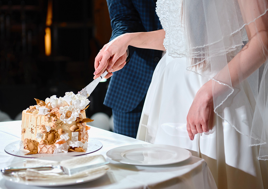 a bride and groom cutting a wedding cake