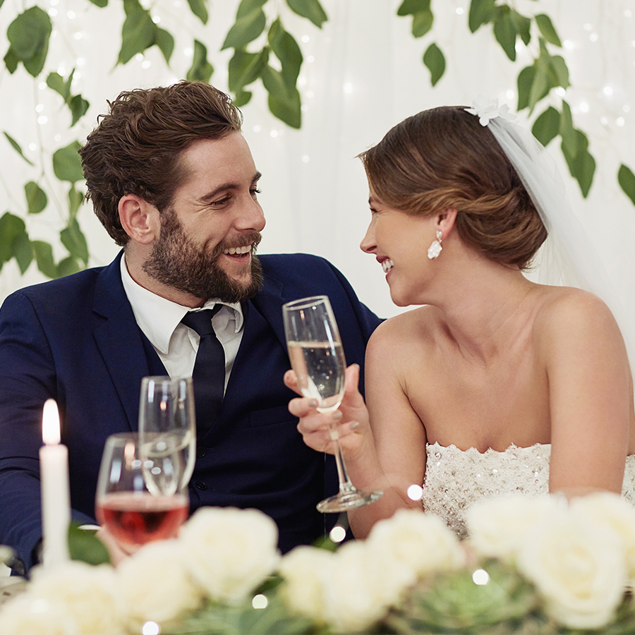 a man and woman sitting at a table with wine glasses