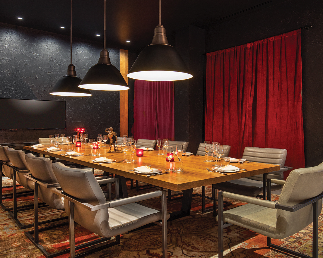 a table with chairs and a red curtain