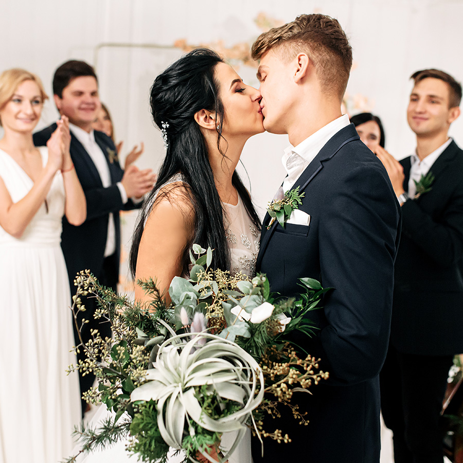 a man and woman kissing in front of a group of people