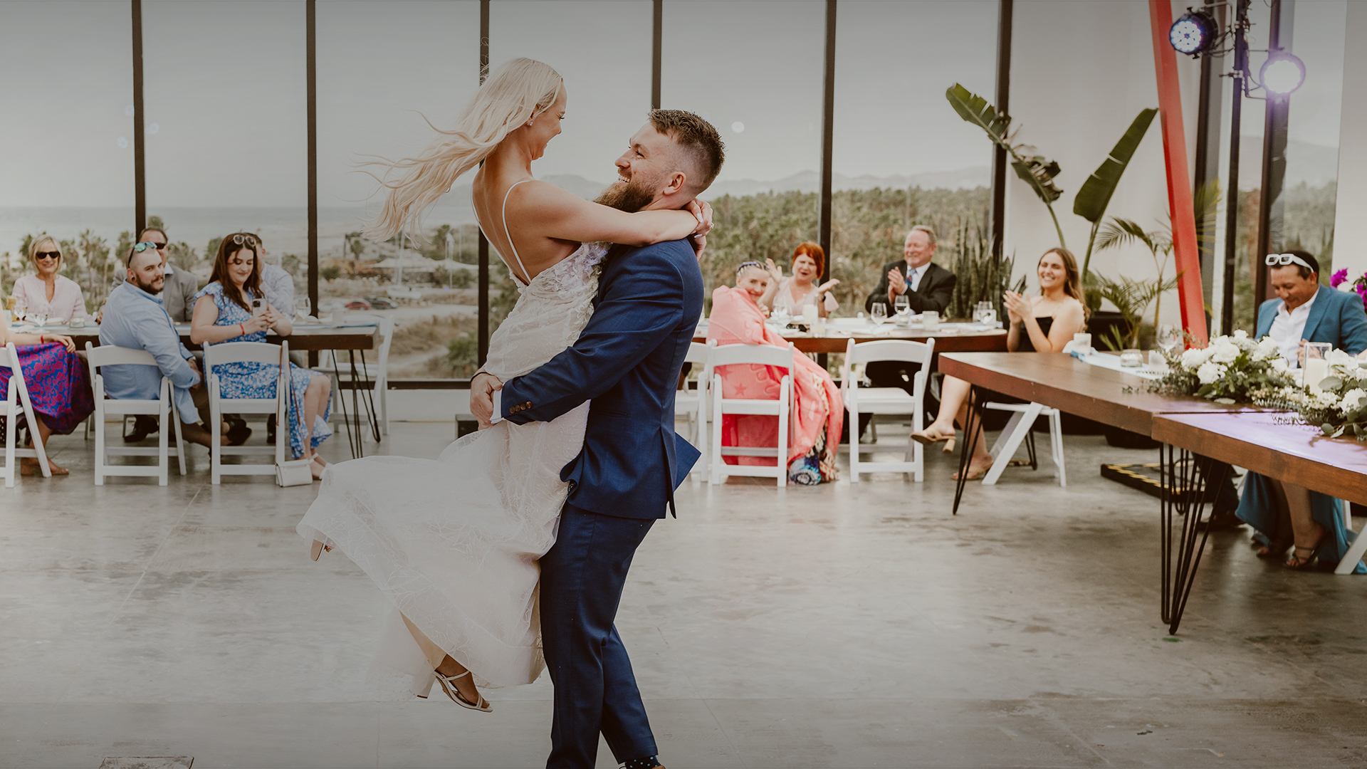 a man and woman dancing in a room with a large window