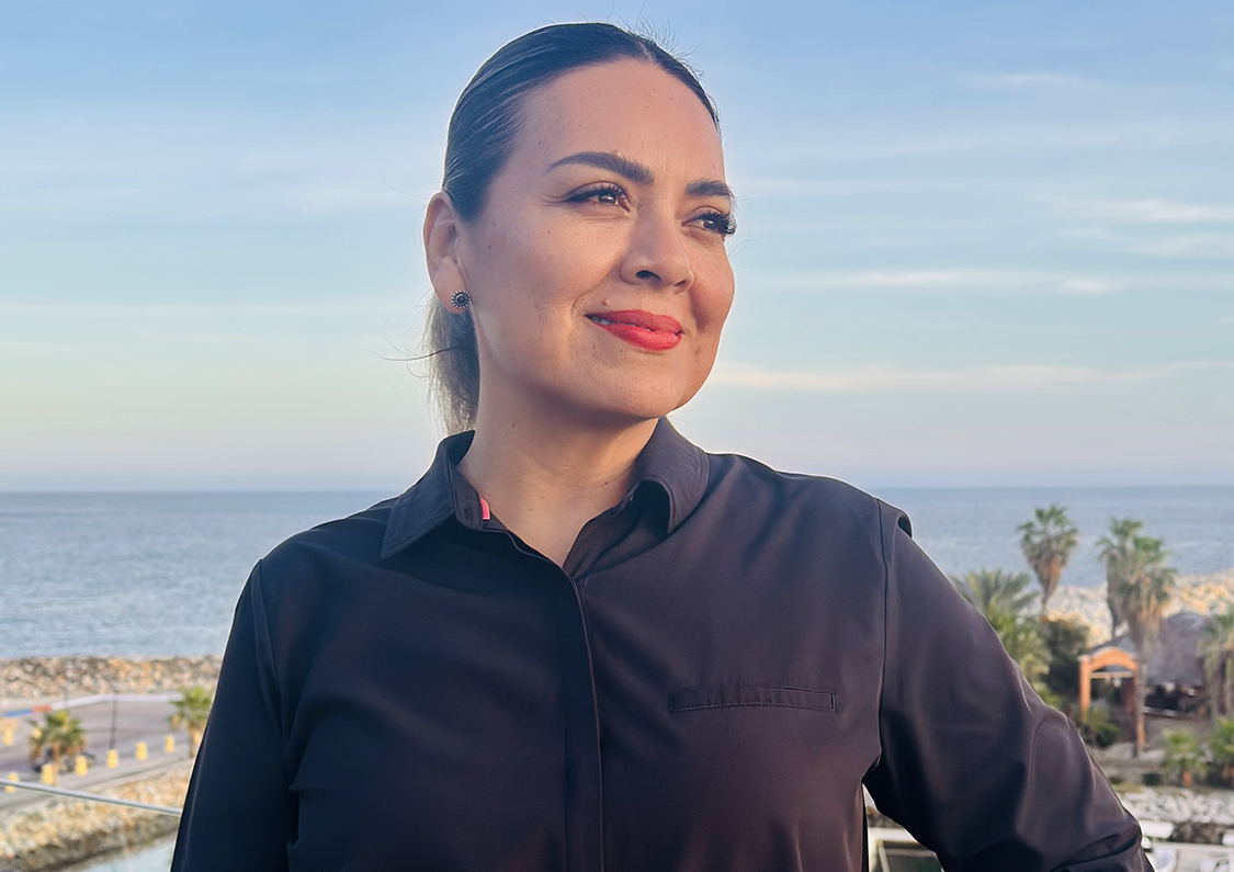 a woman smiling in front of a body of water