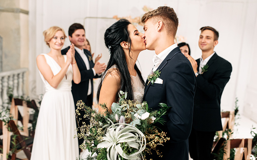 a man and woman kissing in front of a group of people