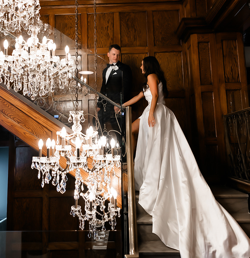 a man and woman in a wedding dress on a staircase